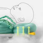 Green baby head protector with white sole and yellow accents on a white background