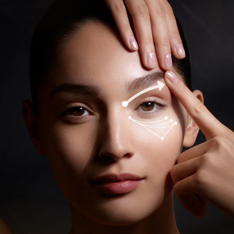 Woman's face with skincare product applied, against a dark background