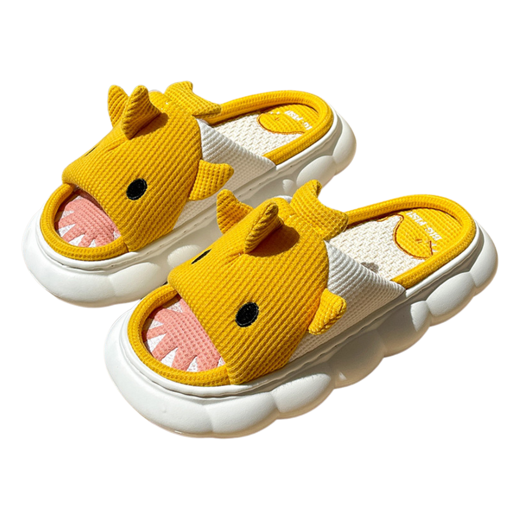 Pair of yellow shark children's slippers with white soles on a white background