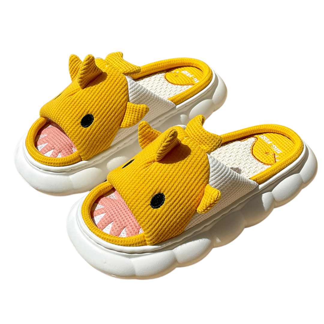Pair of yellow shark children's slippers with white soles on a white background